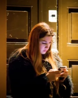 Fotografia d'una dona utilitzant un telèfon mòbil.