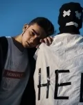 Noi arrepenjat a l'espatlla d'un altre noi amb una capa que hi diu 'Help'. Font: Iluha Zavaley
