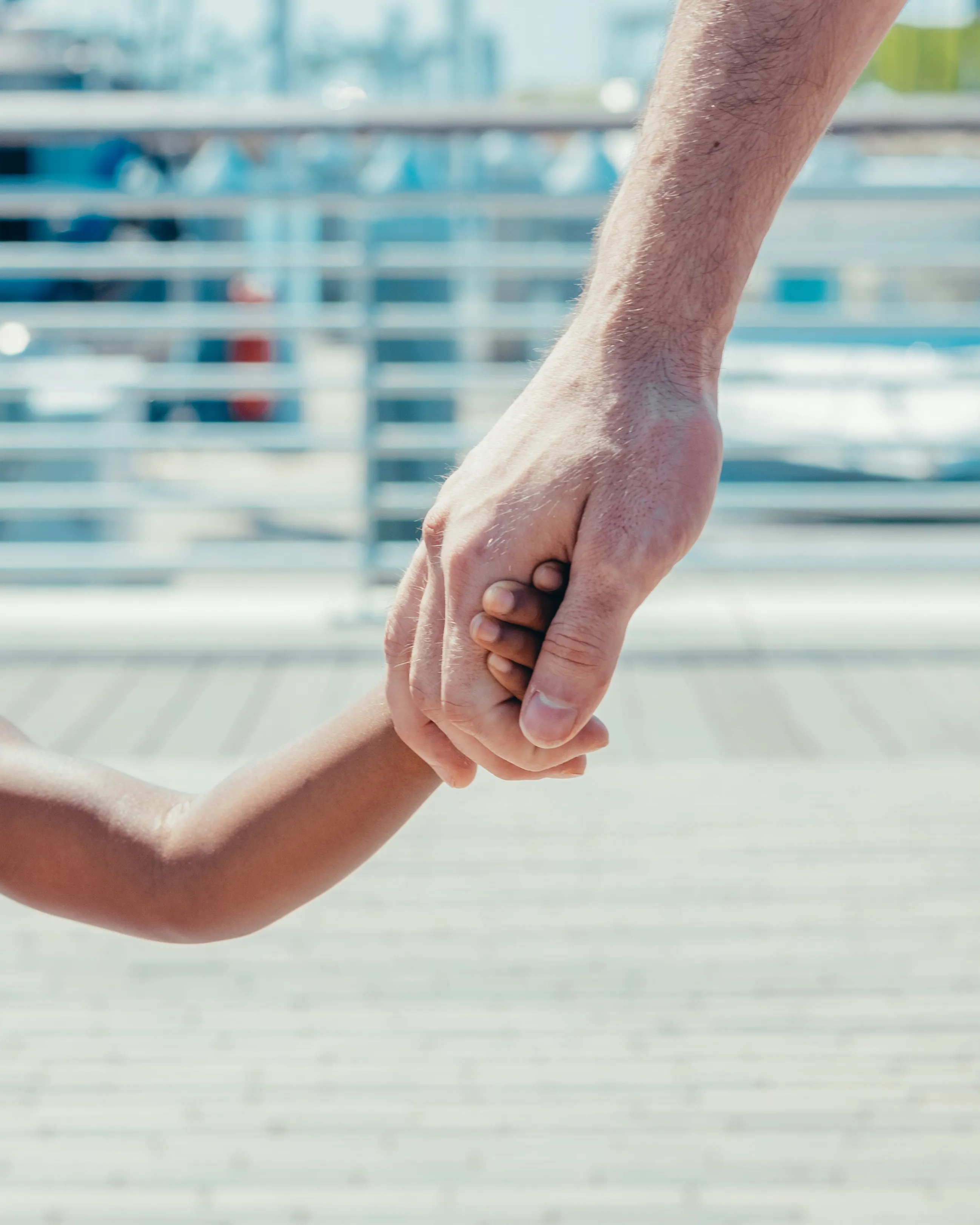 Un adult agafant la mà d'un infant. Font: Pexels - Kindel Media