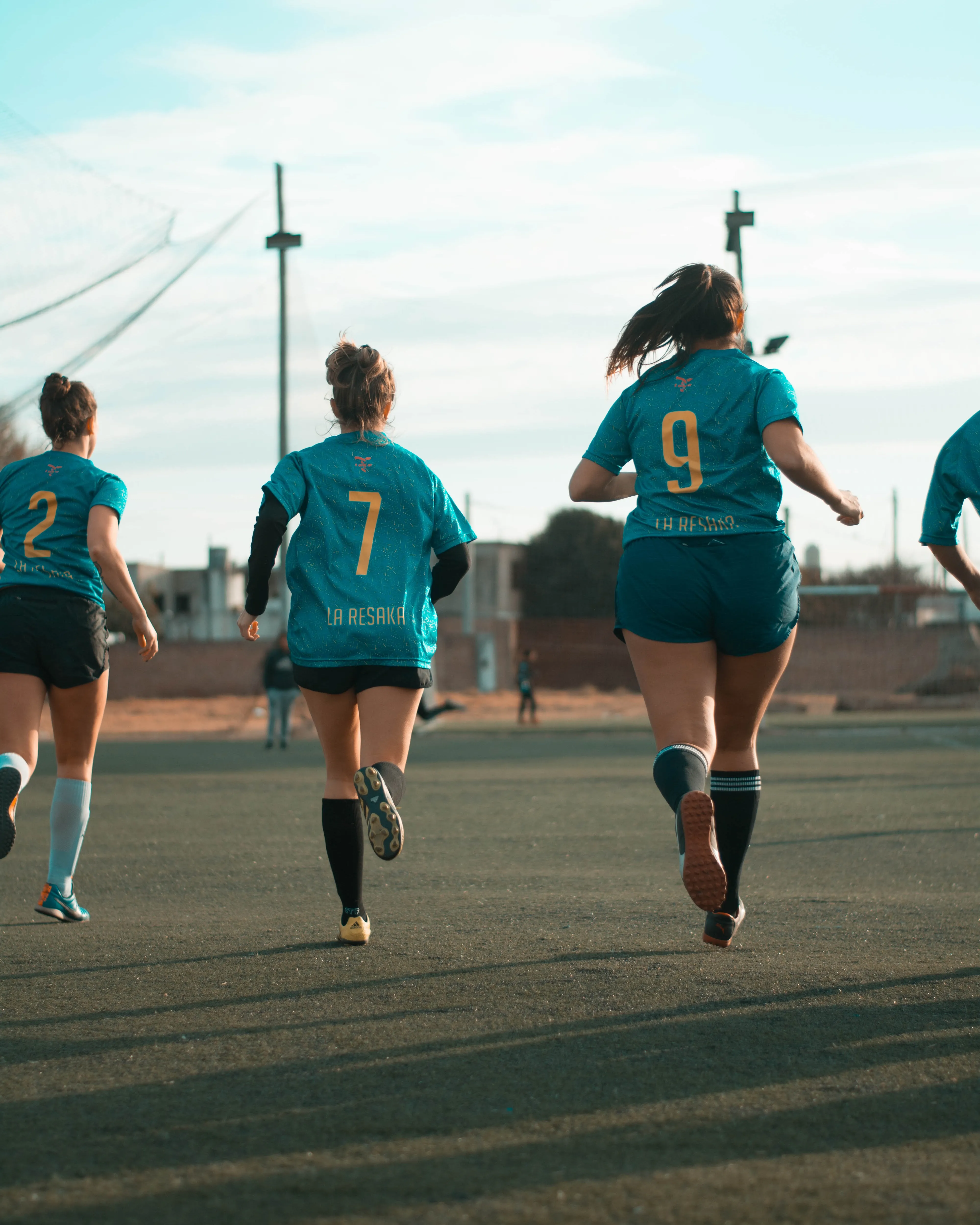 Noies corrent en un camp de gespa. Font: Pexels - Mica Asato