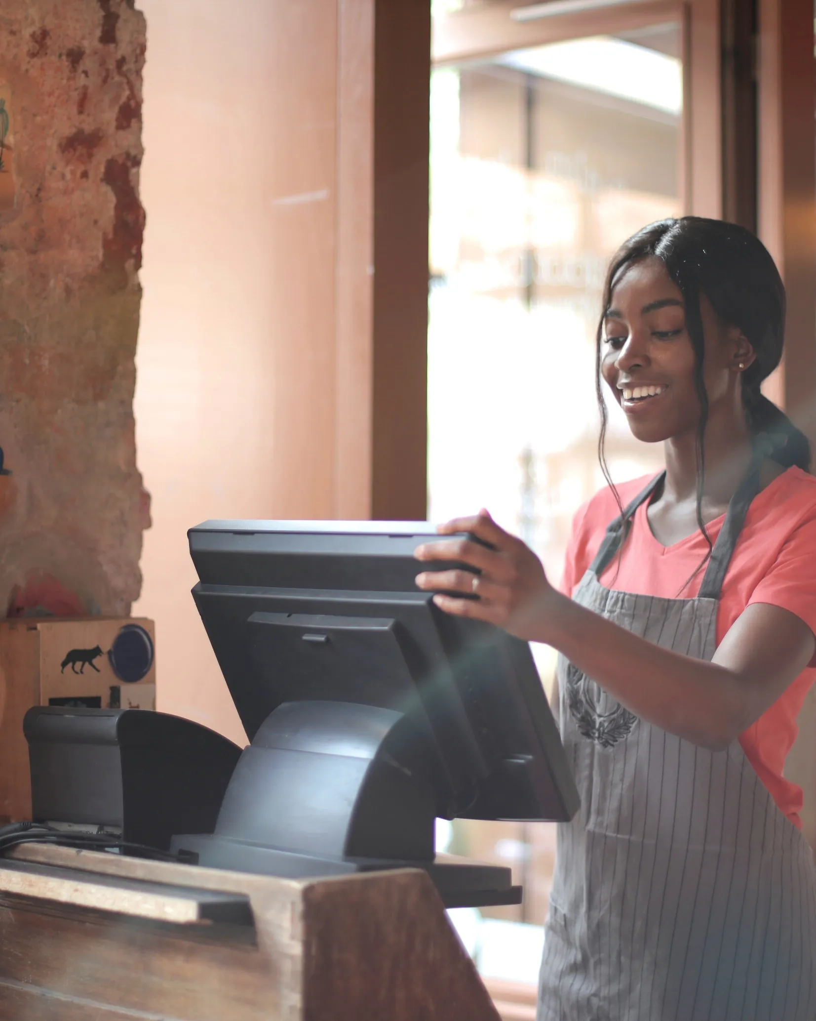 Noia treballant en una caixa d'un restaurant. Font: Pexels - Andrea Piacquadio