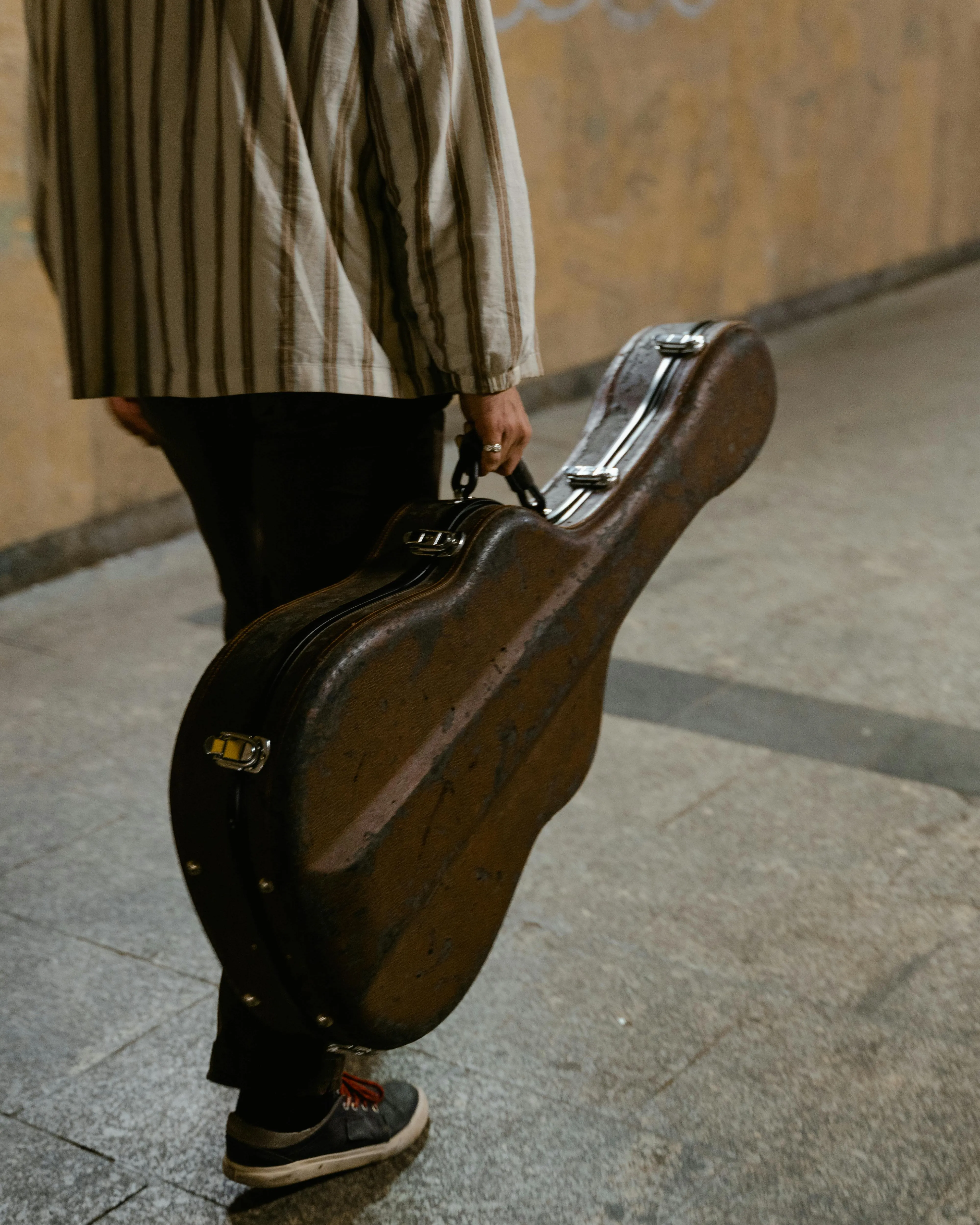 Persona transportant una guitarra en un metro. Font: Pexels - MART PRODUCTION Persona transportant una guitarra en un metro. Font: Pexels - MART PRODUCTION