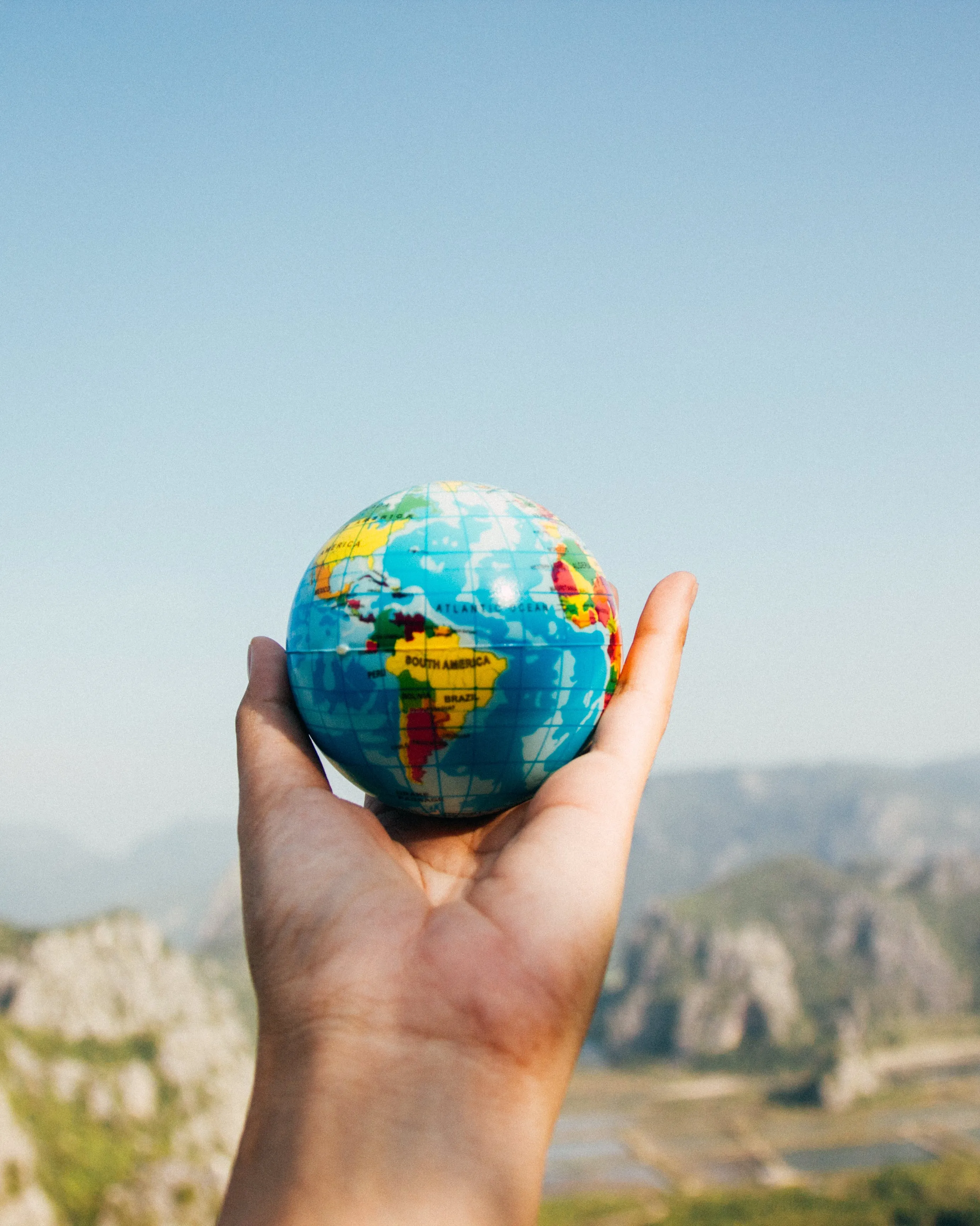 Mà agafant una bola del món. Font: Pexels - Porapak Apichodilok