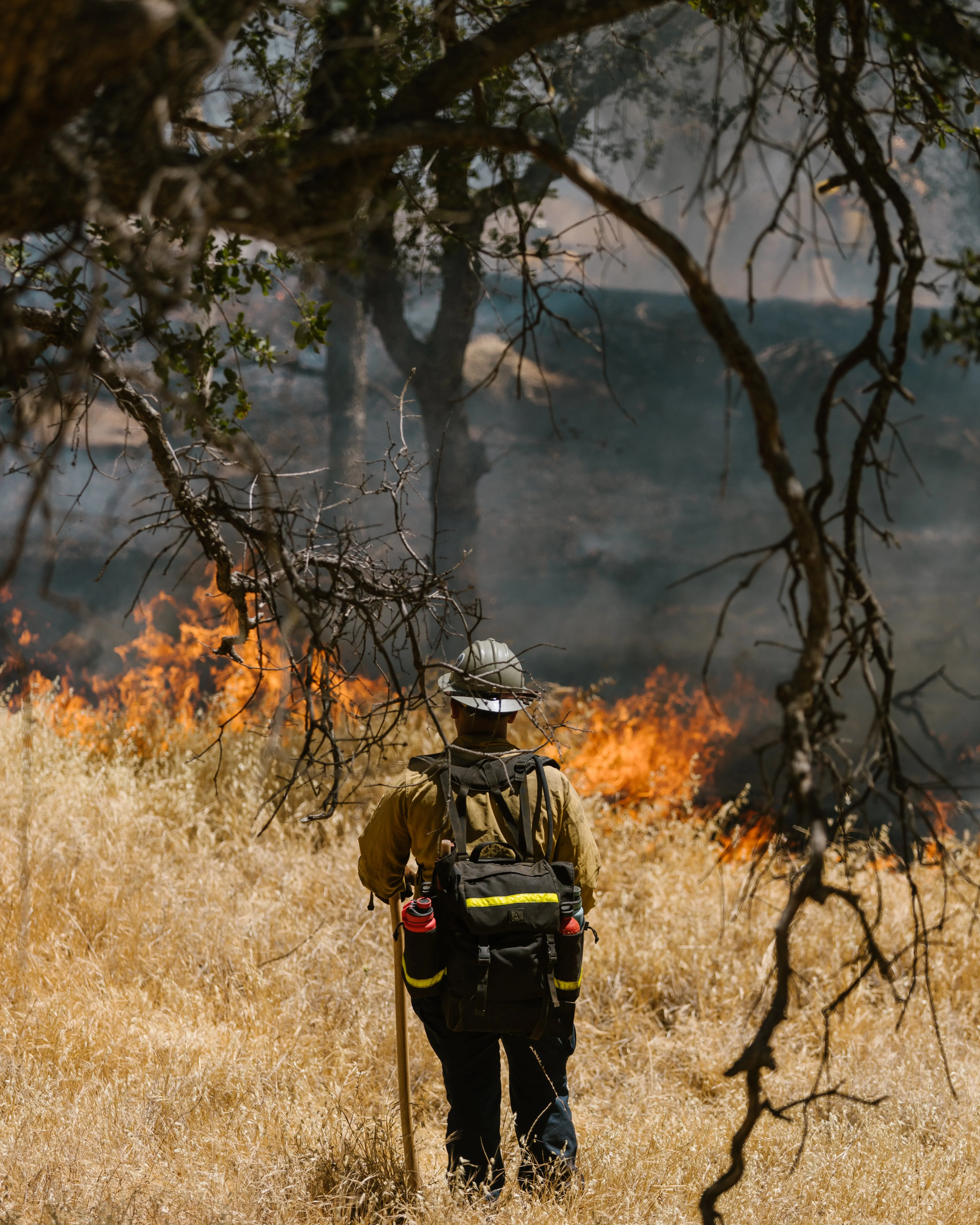 Persona bombera controlant un foc. Font: Pexels - RDNE Stock project