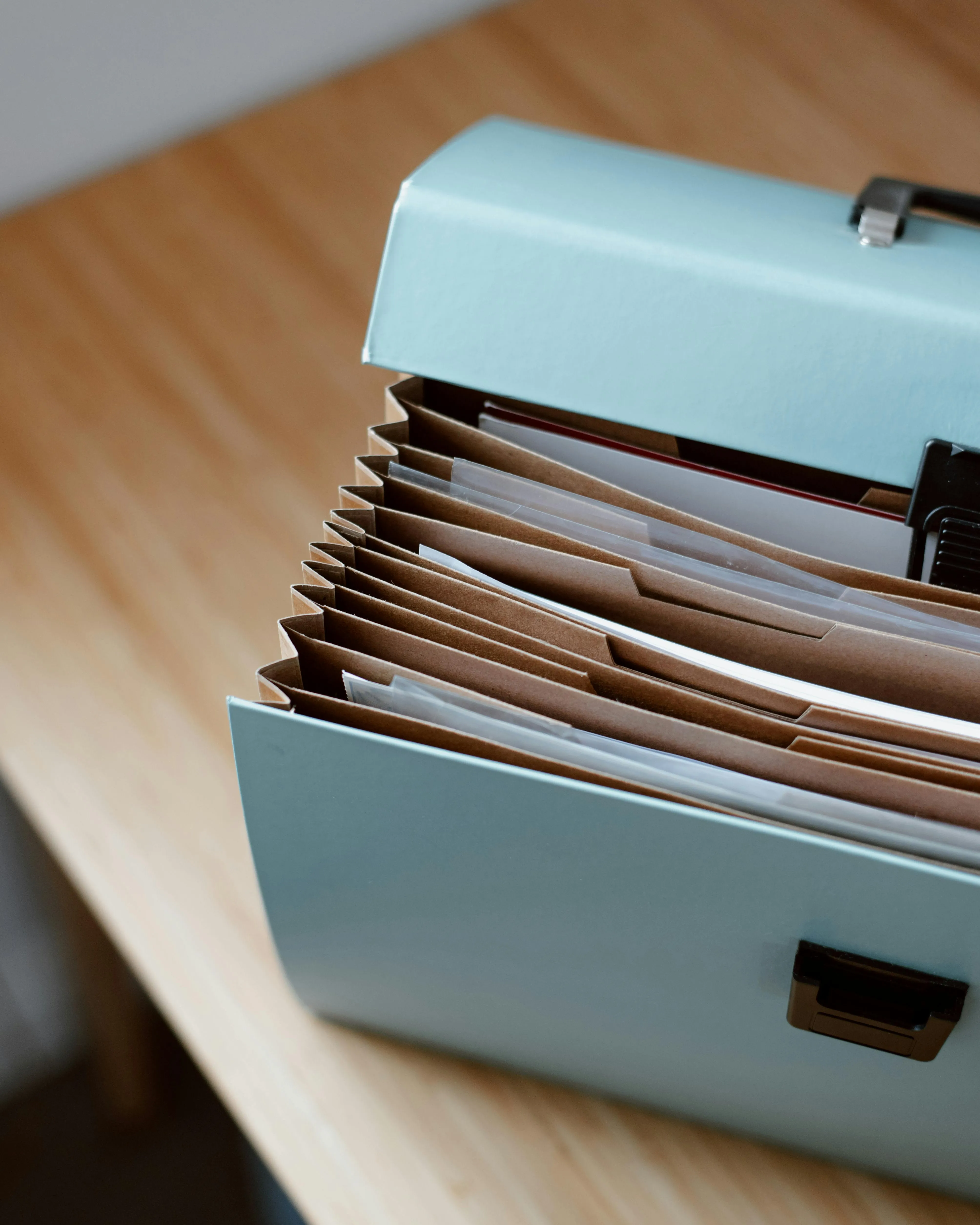 Carpeta arxivadora de papers oberta sobre una taula. Font: Pexels - Anete Lusina