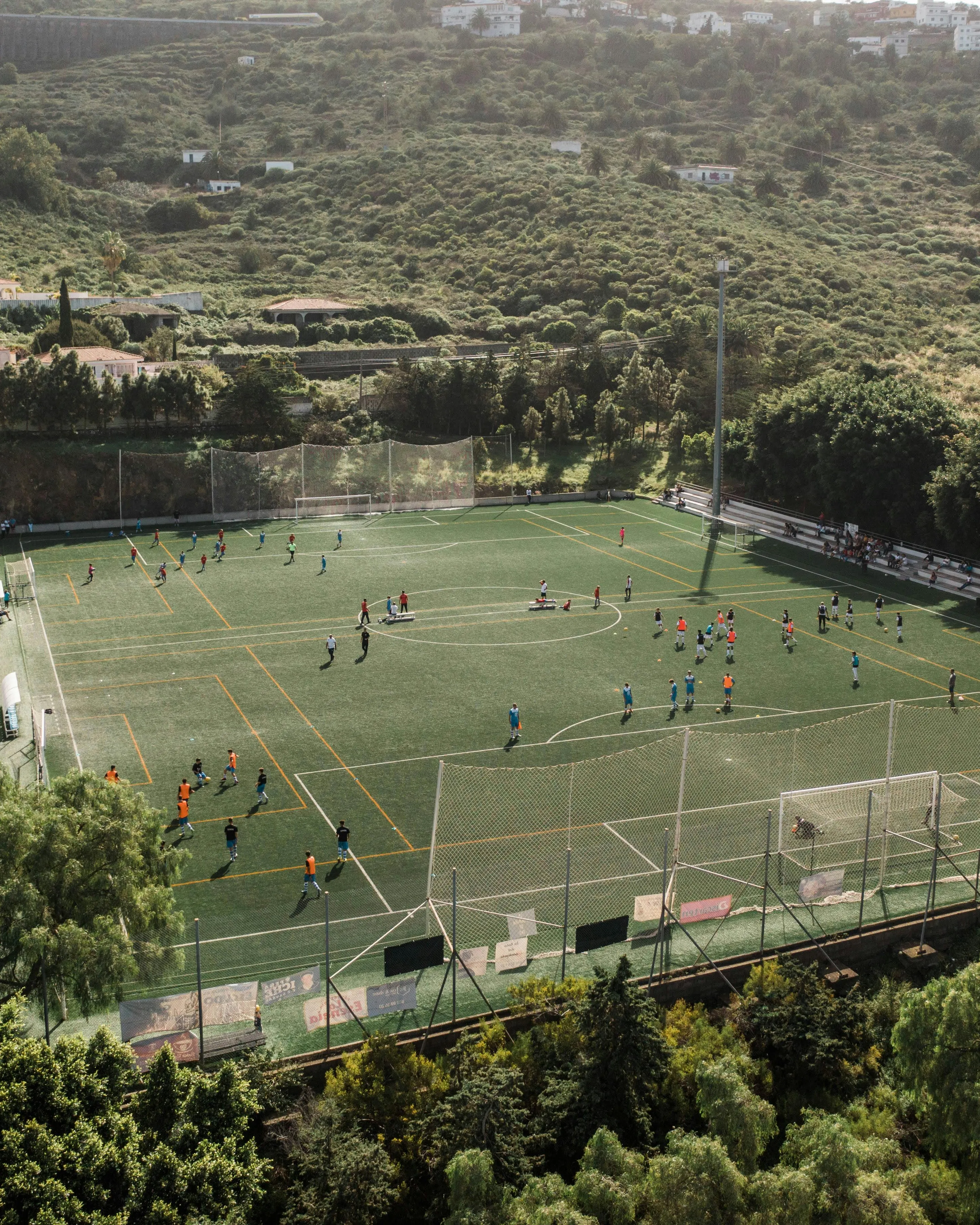 Camp de gespa amb gent entrenant. 