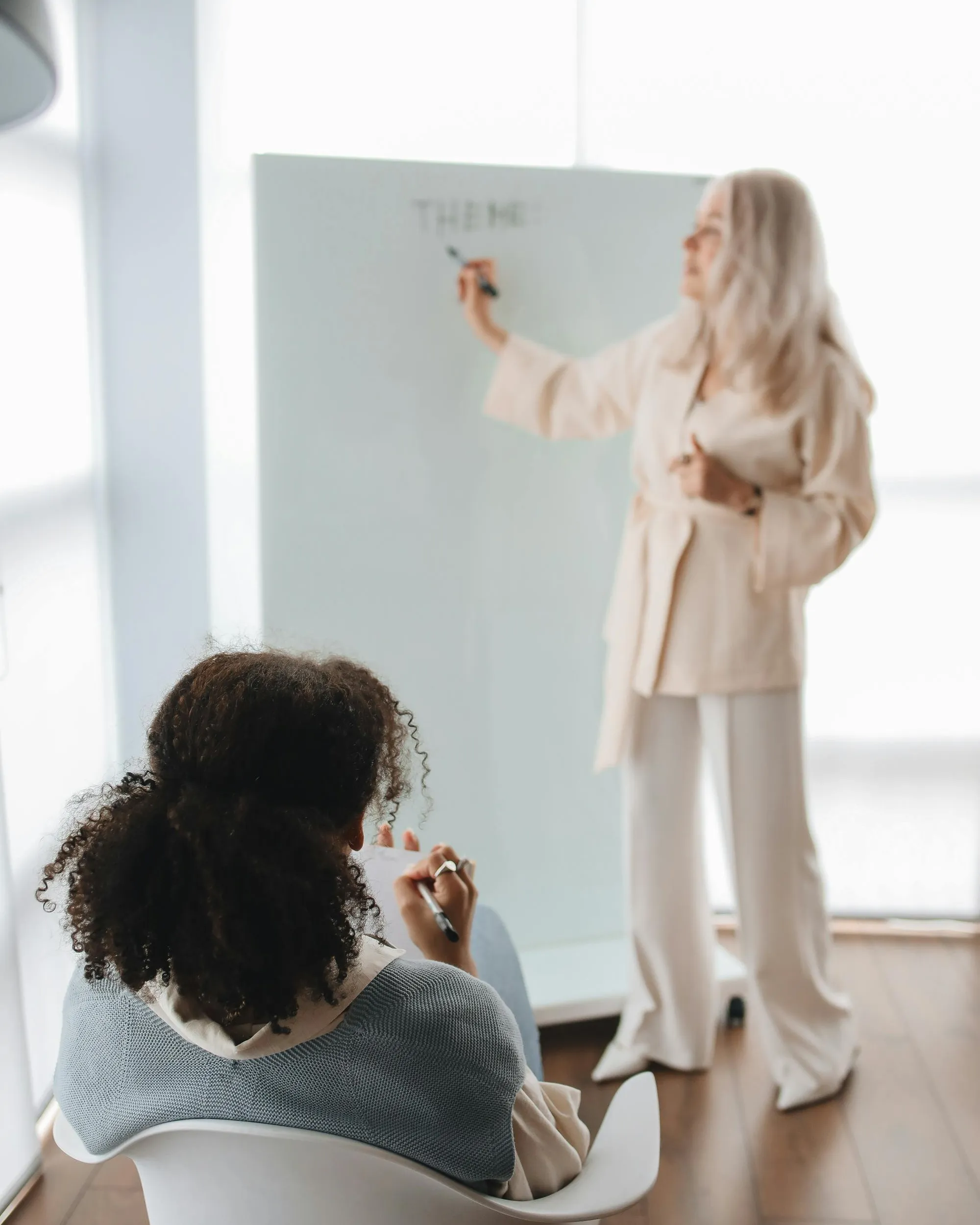 Dona donant classe i alumna escoltant