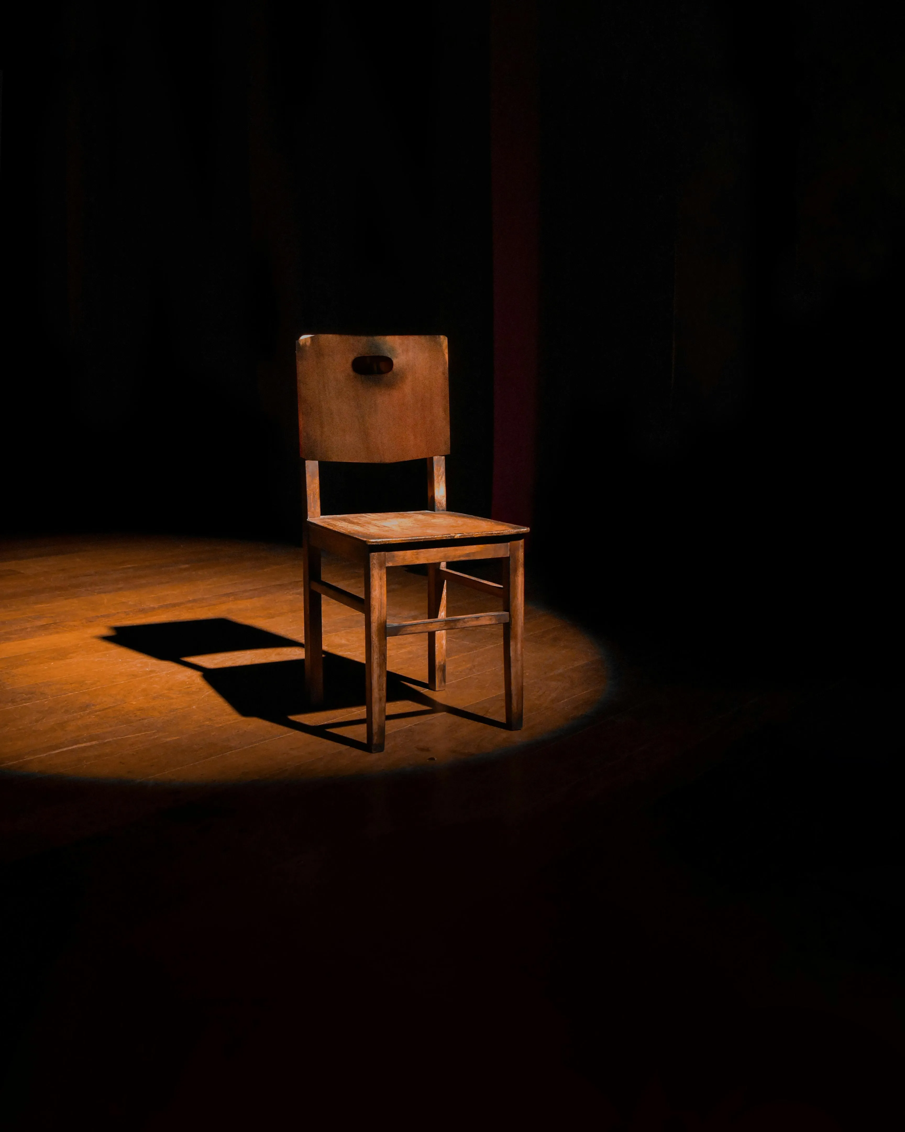 Cadira il·luminada dalt d'un escenari de teatre