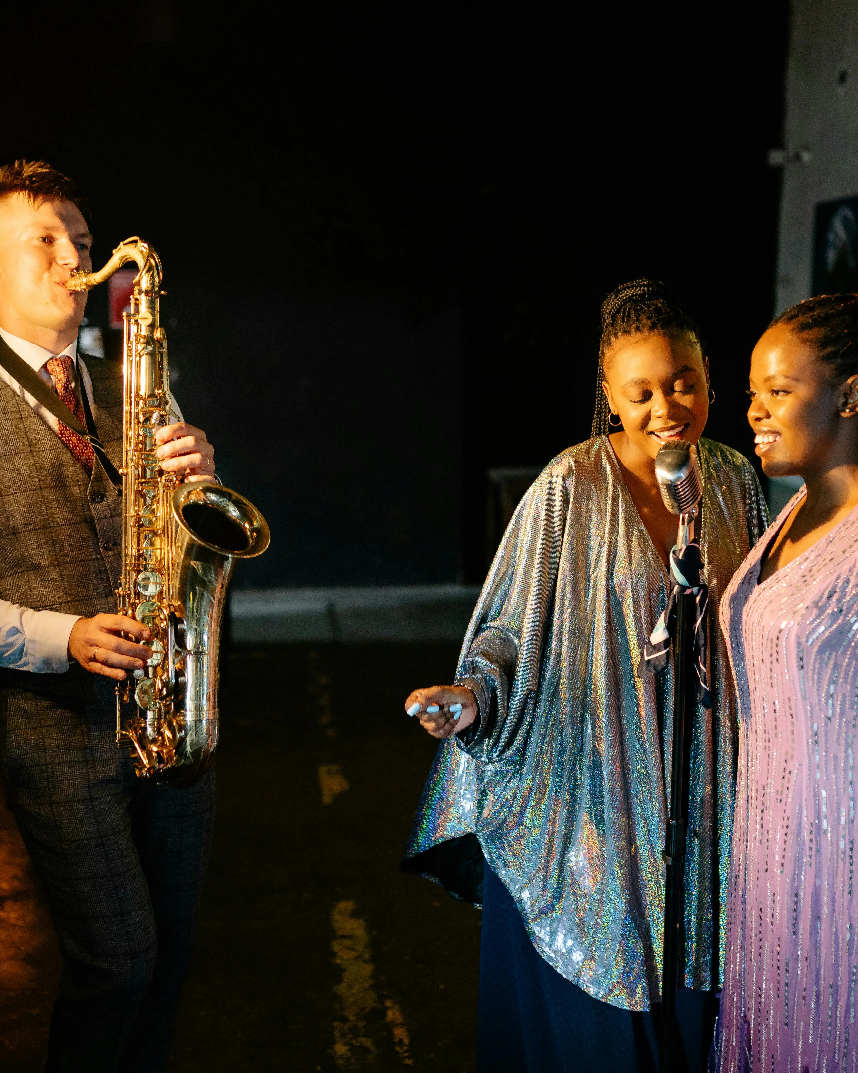 Saxofonista amb cantants de jazz a l'escenari