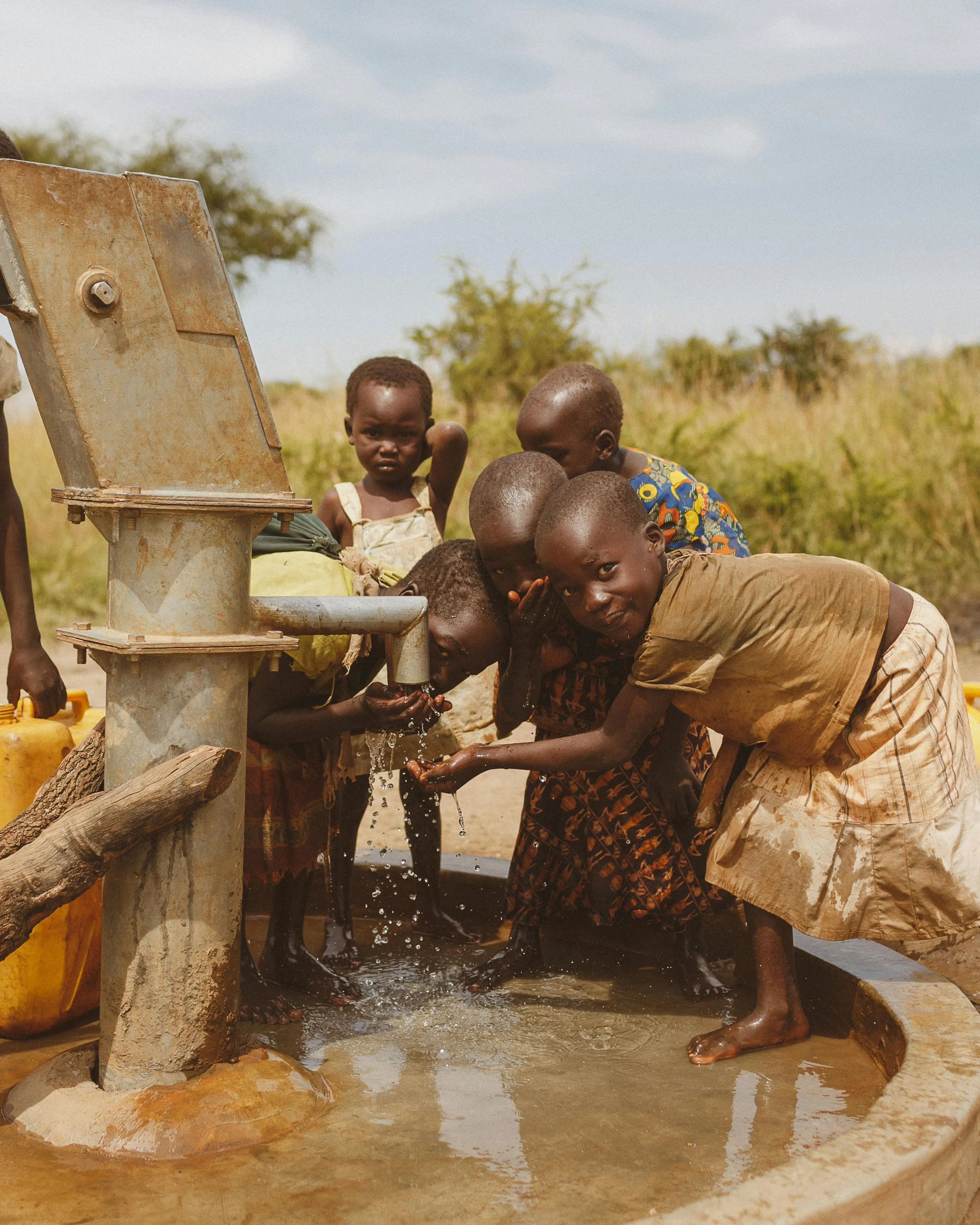 Infants fent funcionar una font a l'Àfrica