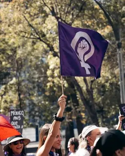 Manifestació de dones amb la bandera feminista