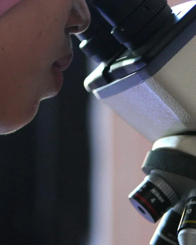 Noia mirant per un microscopi Noia mirant per un microscopi