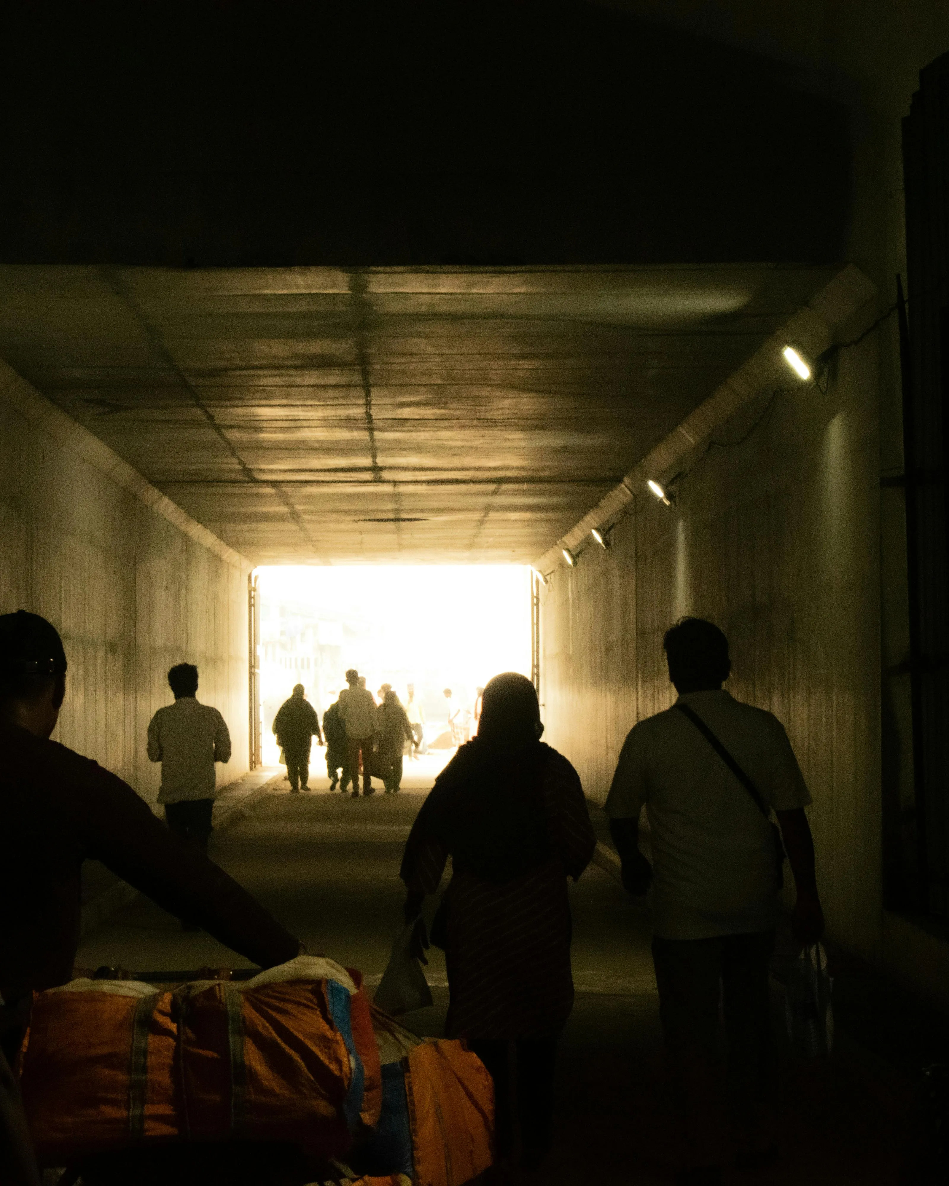 Persones migrants passant per un túnel Persones migrants passant per un túnel