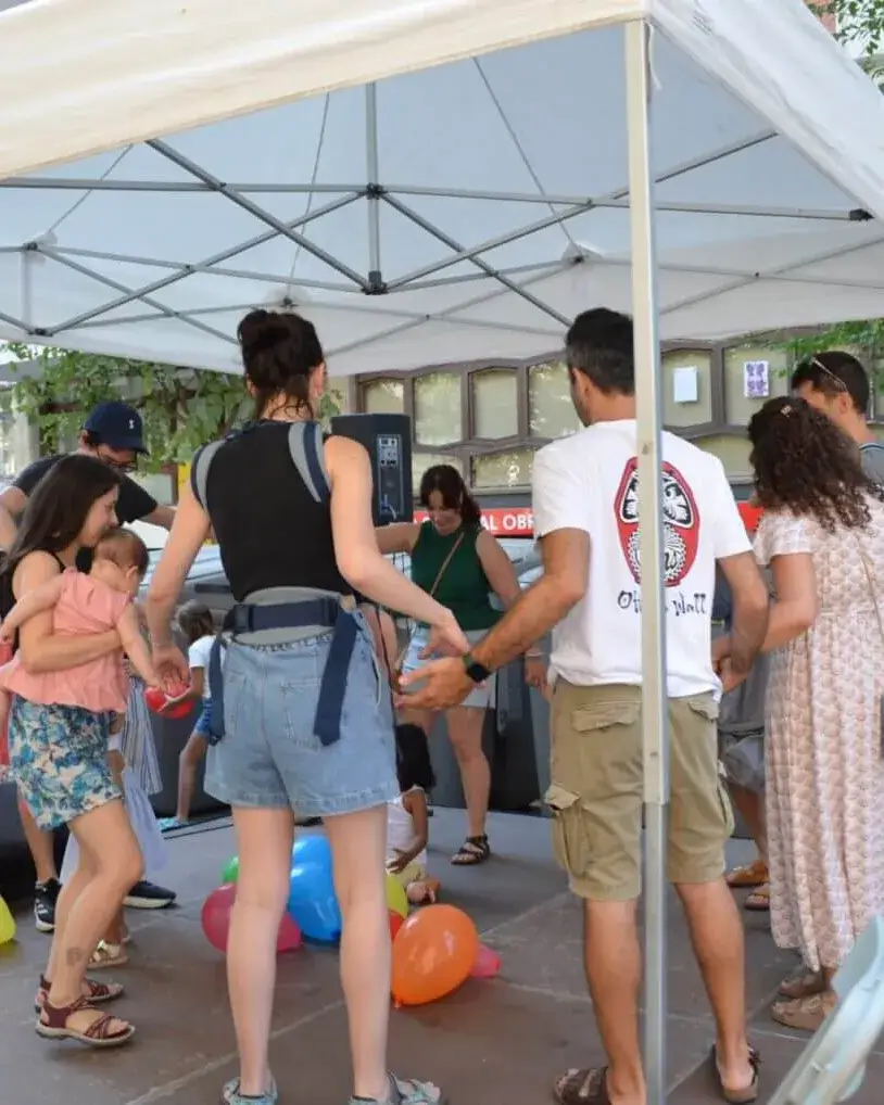 Un grup de persones sota una carpa realitzant una activitat conjuntament.