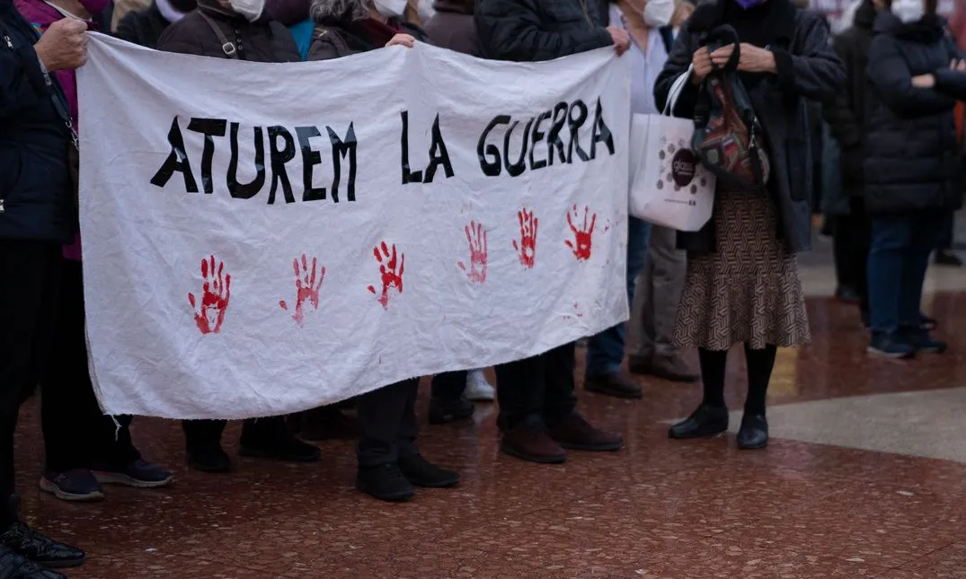 Manifestants a la plaça de Catalunya portant una pancarta per demanar la fi de la guerra d'Ucraïna