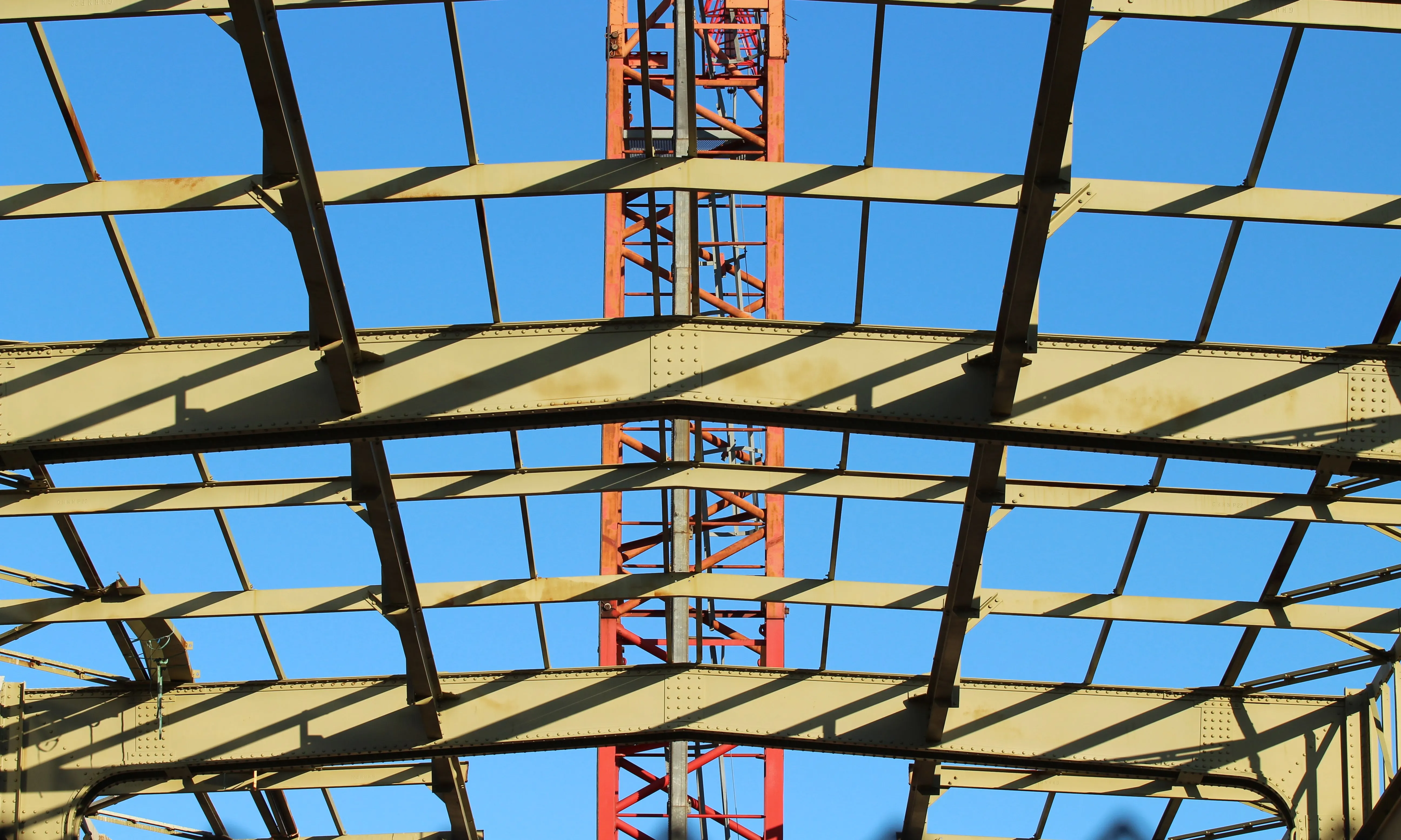 L'esquelet d'un edifici, amb vigues de ferro i una grua al fons. 