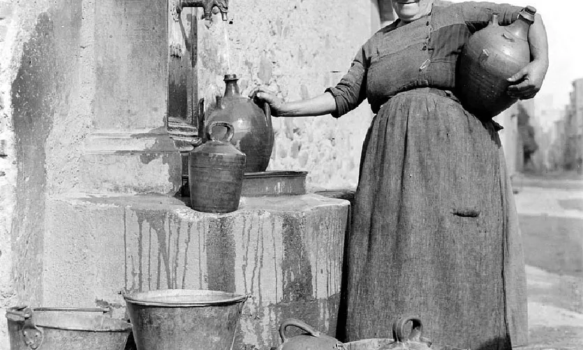 Una dona carrega aigua a la font de la tendera, a l’Espluga de Francolí.