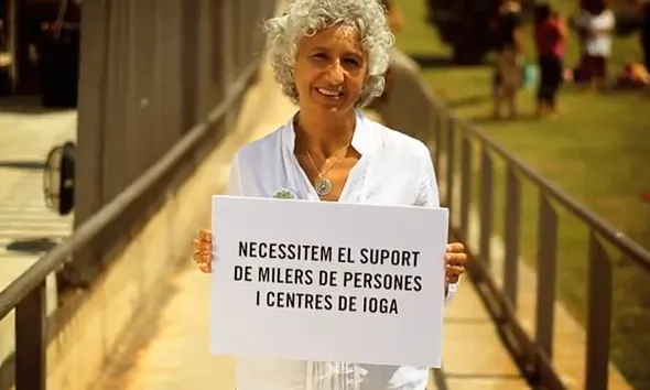 Dona amb cartell del Yoga Day: Necessitem suport!