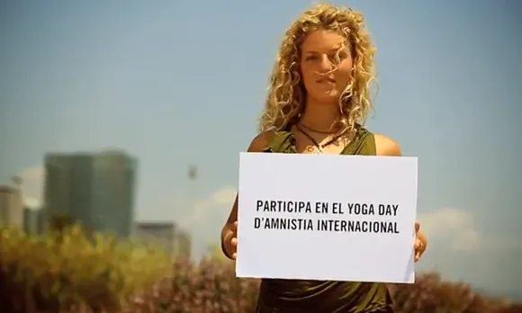 Noia amb cartell del Yoga Day: Participa-hi!