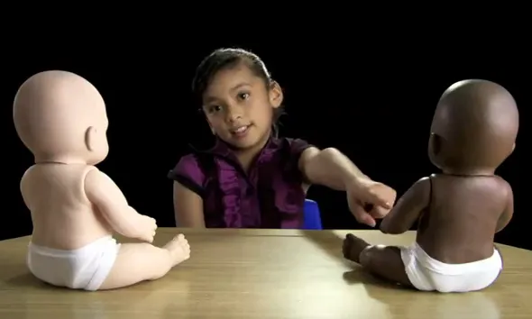 Fotograma amb una nena i 2 ninots del vídeo de la campanya Racismo en México