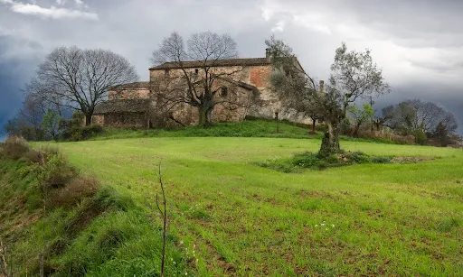 Fotografia d'una masia en un camp verd