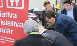 Un grup de persones signen per la ILP