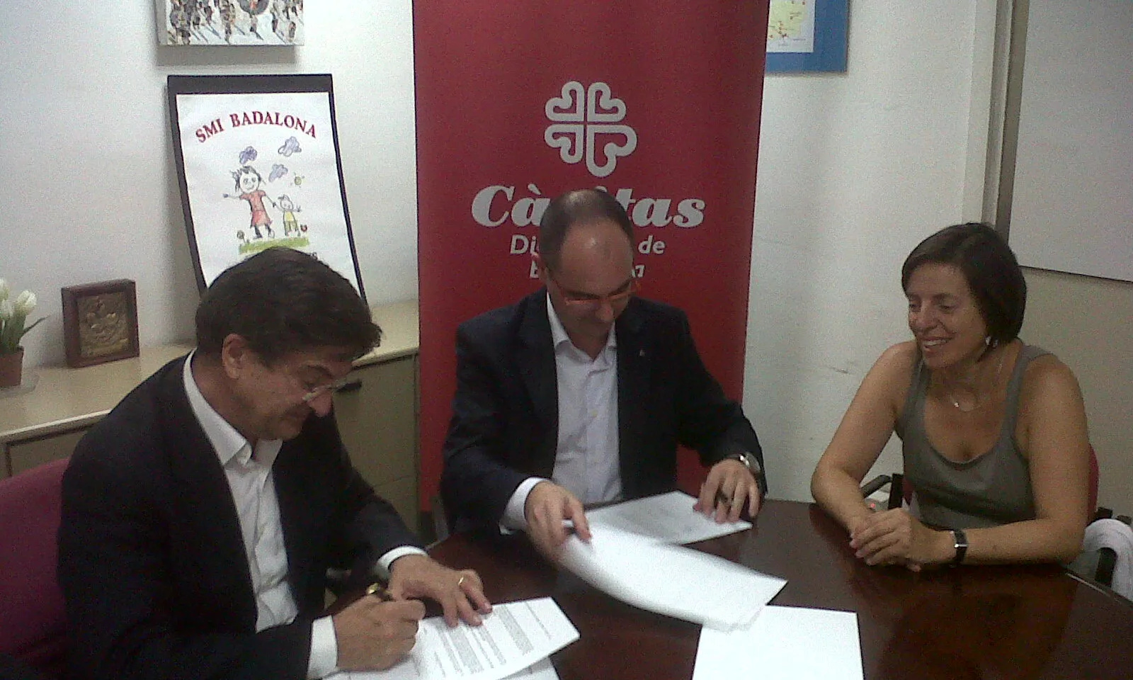 Imatge de la signatura del conveni entre la FAC i Càritas.