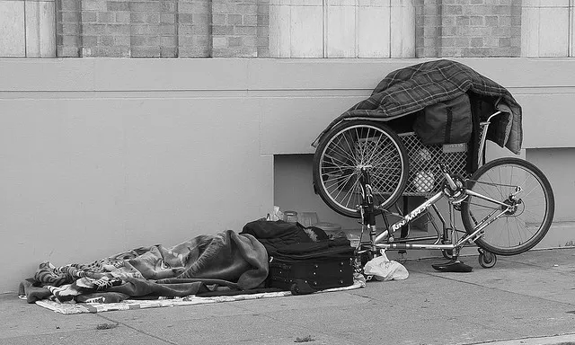 Homeless reading on the sidewalk. Fotografia de l'usuari Flickr Franco Folini