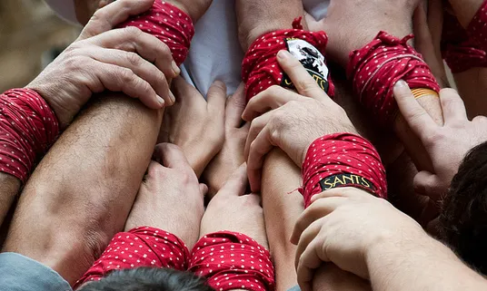 Mans de castellers fent pinya. Dani Alvarez Cañellas