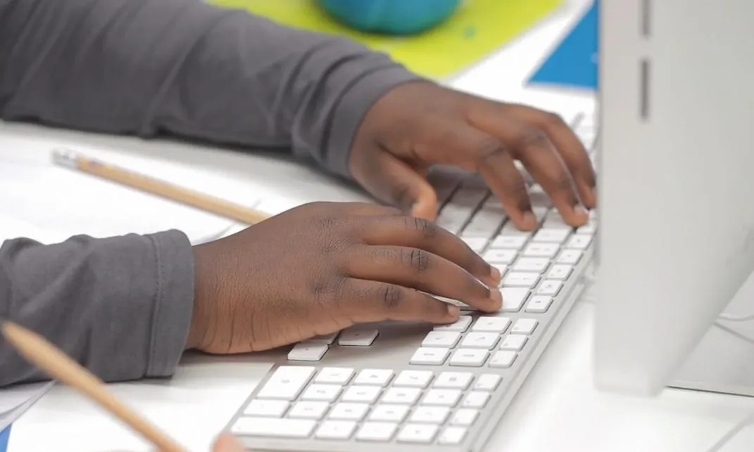 Mans d'un nens sobre un teclat durant un taller. Font: Inmatge (www.inmatge.com)