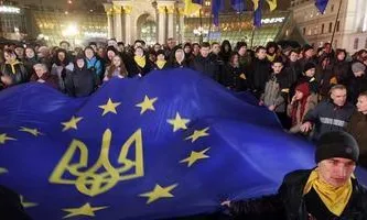 Uns ucraïnesos amb banderes europees a la plaça de la Independència, Kíev (EFE)