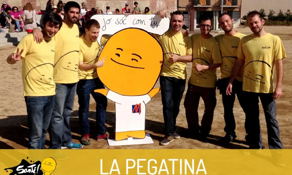 El grup La Pegatina amb una reproducció en cartró de la figura d'en Santi