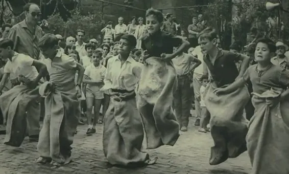 Infant jugant a sacs en una imatge històrica de les Festes de Sant Roc
