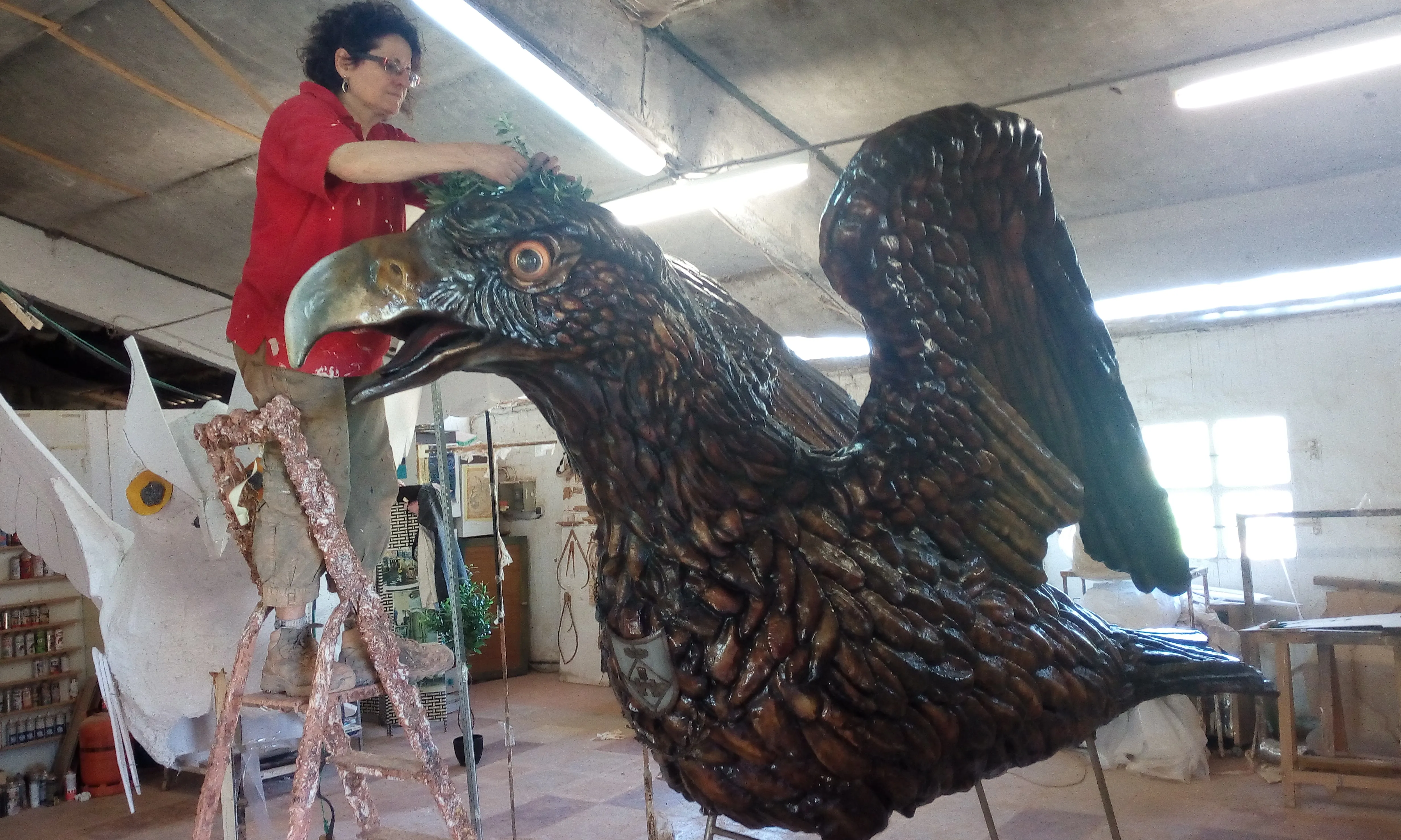 Dolors Sans al seu taller de Vilafranca reparant l'àliga de les ales obertes.