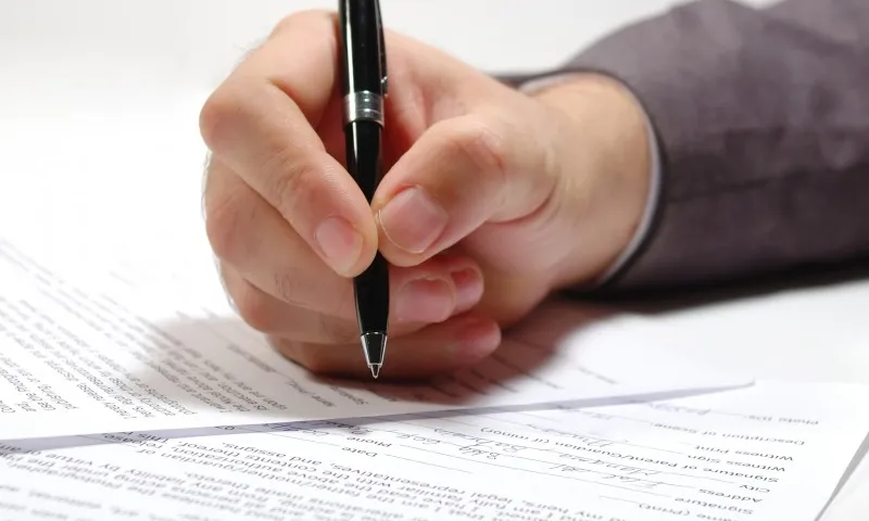 Persona signant un contracte. Font: Associació Valenciana de Ceràmica