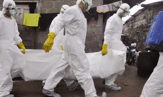 Metges carregant una persona sense vida com a conseqüència de l'ebola (Font: MSF)