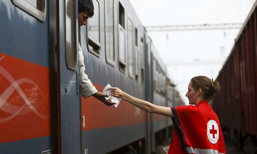 Una voluntària de la Creu Roja repartint aigua