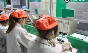 Treballadores en una cadena de muntatge de maquinari electrònic