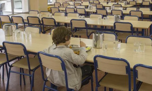 Nen menjant en un menjador escolar. Font: web elpais.com