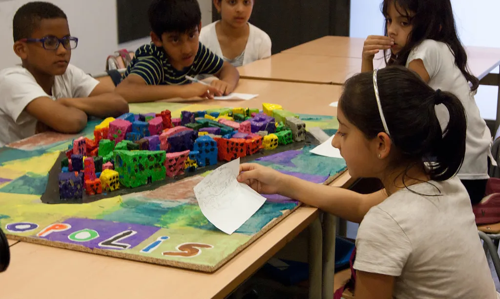 Participants en el projecte davant la maqueta. Font: web de Xarxa Òmnia