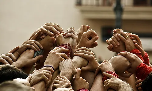 Mans unides fent pinya. Font: in.directe.cat