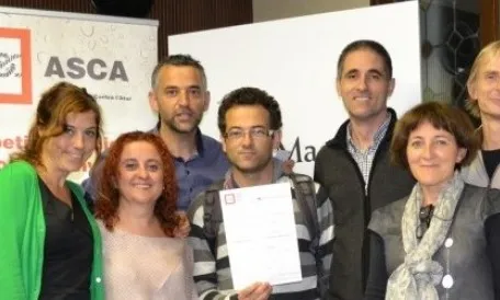 Membres de la cooperativa Tapurna ensenyant el premi que van rebre al 2014