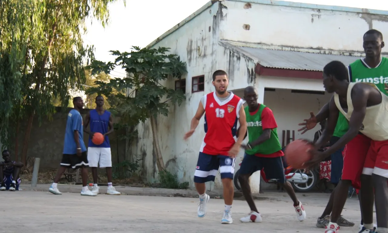 Albert Francolí, al mig, a la pista de bàsquet del Centre Catalunya, una escola del Senegal que rep el suport de Caldes Solidària. Font: Caldes Solidària
