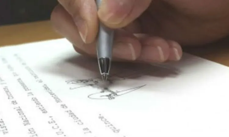 Mà signant documents. Font: www.siicex.gub.uy