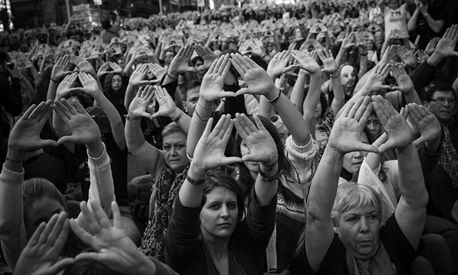 Un grup d'activistes alçant els braços per mostrar el símbol feminista