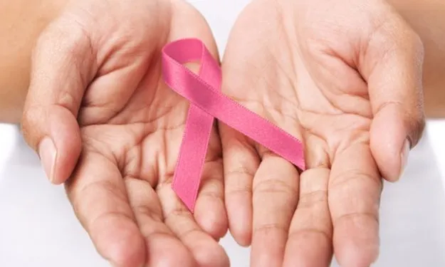 Unes mans amb un llaç de color rosa, símbol de la lluita contra el càncer 