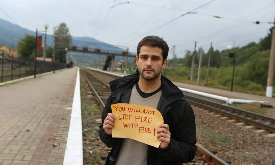 Edouard Portefaix d'Ucraïna amb un cartell que diu en anglès: No parareu el foc amb el foc