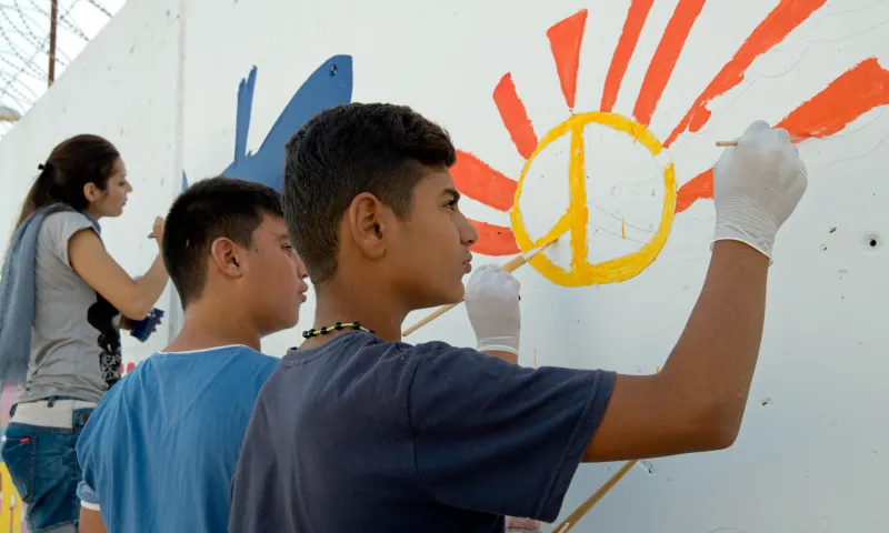Joves dibuixant un mural. Projecte Youth4Peace