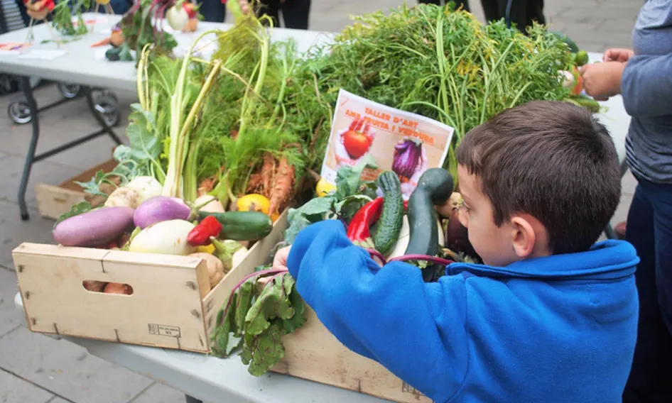Nen amb dues capses de productes agrícoles