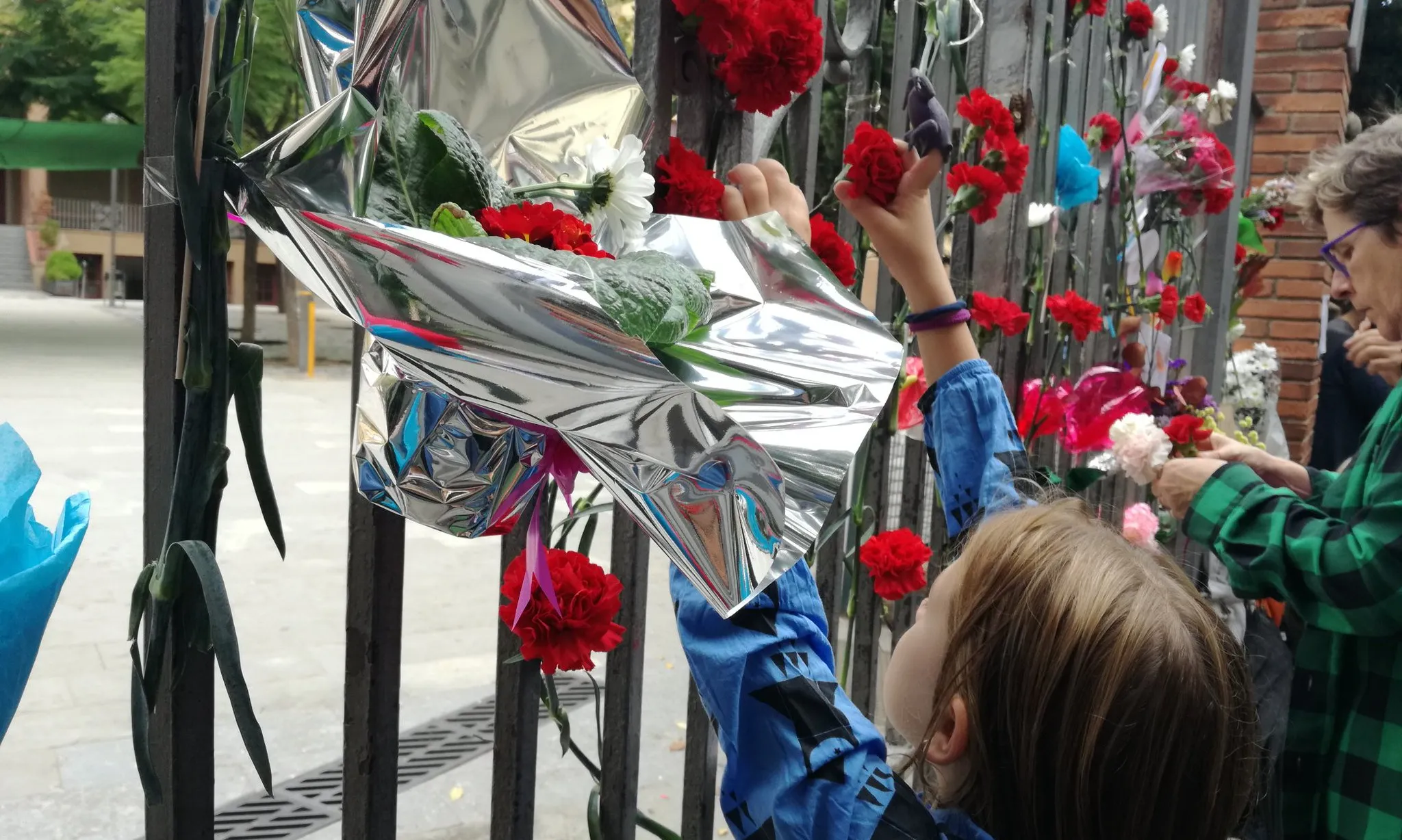 Una nena porta flors a l'escola Ramon Llull de Barcelona